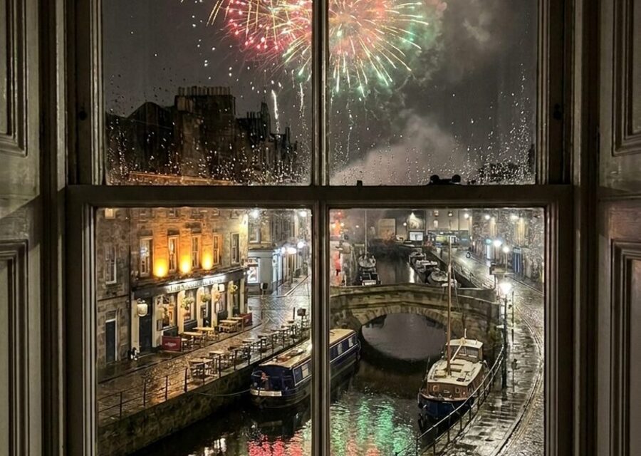 Fireworks over an Edinburgh canal, seen through a rain-streaked window